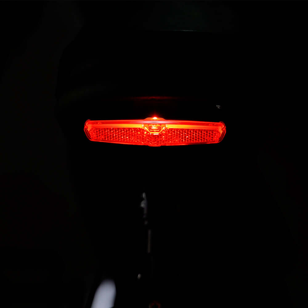 Red rear brake light of Tracer Verge 20" eBike enhances visibility and safety during nighttime rides.